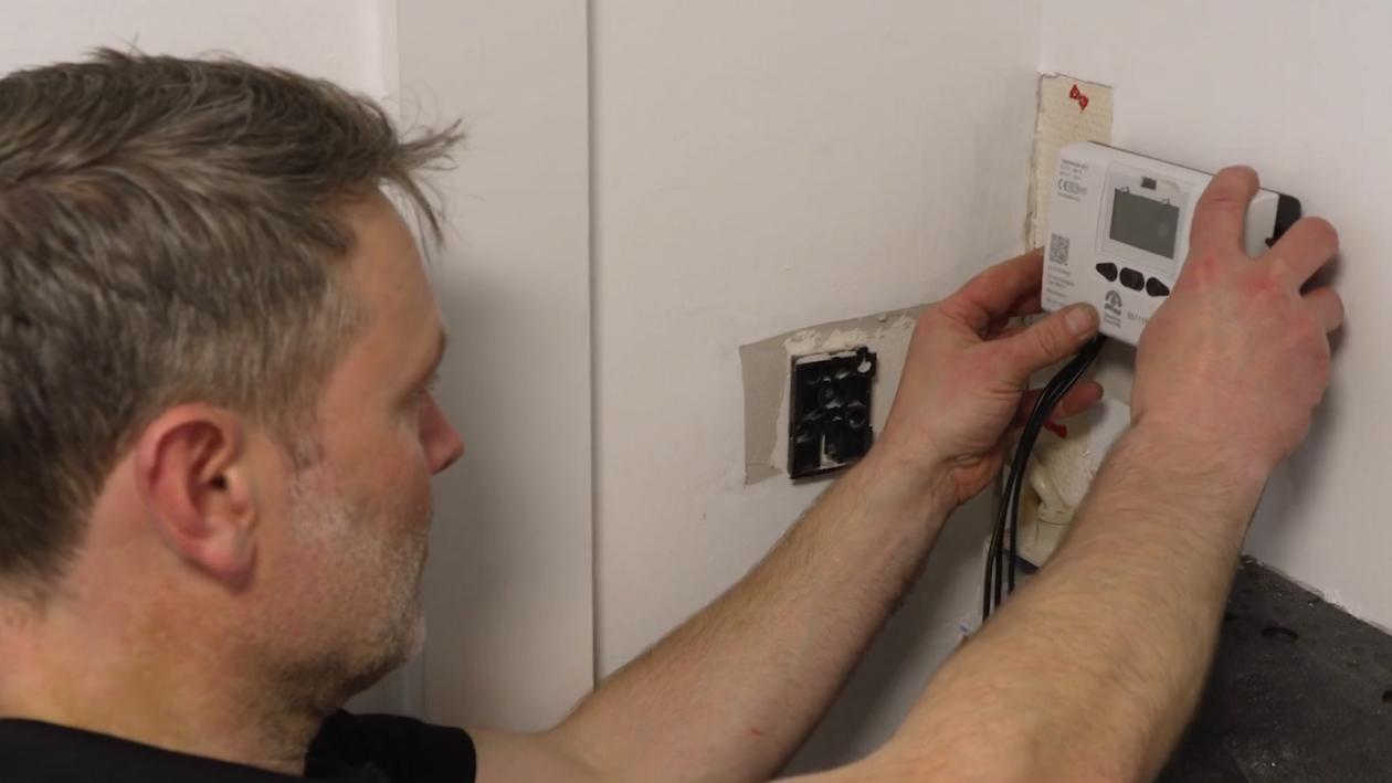 Installatør som er ved at sætte en ny måler op